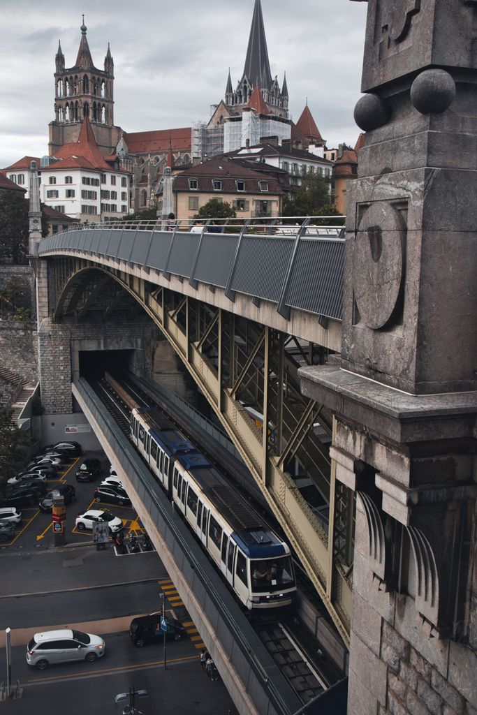 A scenic view of Lausanne's metro system passing below the historic Cathedral Saint Pierre.